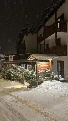 a sign in the snow in front of a building at Mazzantini appartamento vacanza San Martino di Castrozza in San Martino di Castrozza