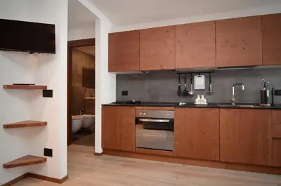 a kitchen with wooden cabinets and a sink at Mazzantini appartamento vacanza San Martino di Castrozza in San Martino di Castrozza