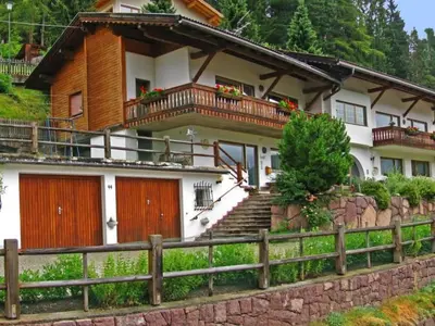 a house with wooden doors and a fence at Apartment mit privatem Balkon by Interhome in Ortisei