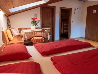 two beds in a room with a table and a dining room at Apartment mit privatem Balkon by Interhome in Ortisei
