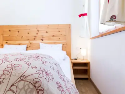 a bedroom with a bed with a floral bedspread at Apartment Zirbe by Interhome in Selva dei Molini