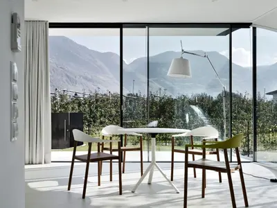 a dining room with a table and chairs in front of a window at Holiday Home Mirror House Nord by Interhome in Bolzano
