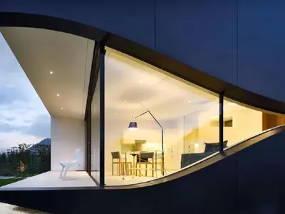 a large window of a house with a white chair at Holiday Home Mirror House Nord by Interhome in Bolzano
