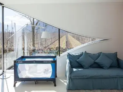 a living room with a couch and a large window at Holiday Home Mirror House Nord by Interhome in Bolzano