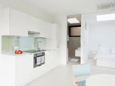 a white kitchen with white cabinets and a sink at Holiday Home Mirror House Nord by Interhome in Bolzano