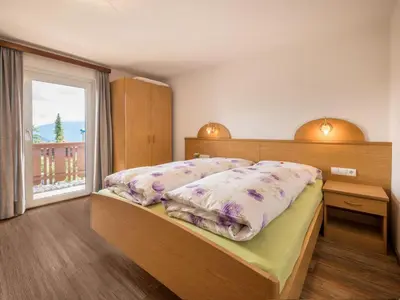 a bedroom with a bed and a large window at Apartment Haus Adler by Interhome in Maranza