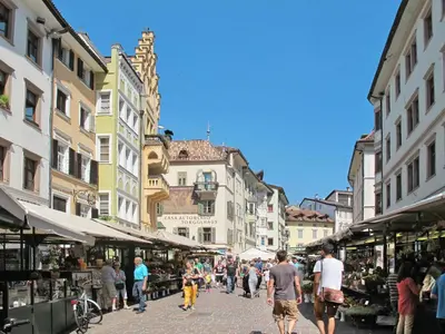 a group of people walking through a street with buildings at Apartment Haus Adler by Interhome in Maranza