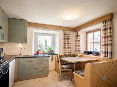 a kitchen with green cabinets and a table and a window at Apartment Haus Adler by Interhome in Maranza