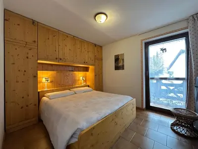 a bedroom with a large bed and a window at Il Gufo Bianco in Carano