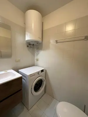 a bathroom with a washing machine and a sink at Il Gufo Bianco in Carano