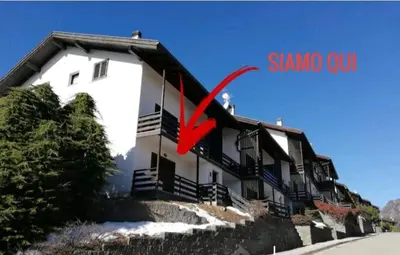 a large white building with a red arrow on it at Il Gufo Bianco in Carano