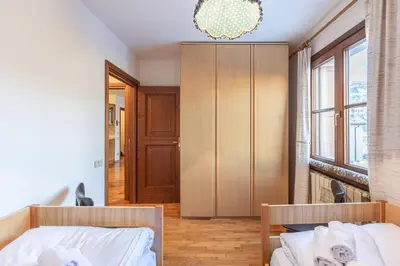 a bedroom with a bed and a wooden cabinet at Casa Tre Corone, sulla strada per Cortina in Borca di Cadore