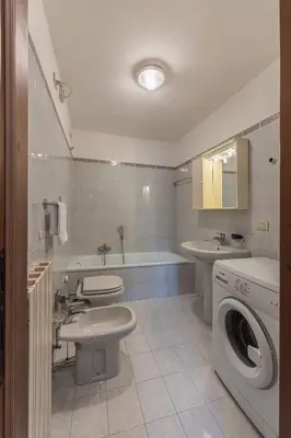 a bathroom with two toilets a sink and a washing machine at Casa Tre Corone, sulla strada per Cortina in Borca di Cadore