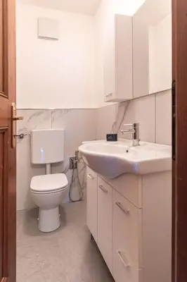 a white bathroom with a toilet and a sink at Casa Tre Corone, sulla strada per Cortina in Borca di Cadore