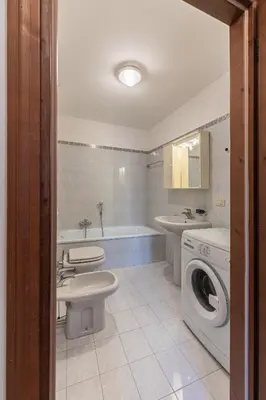 a bathroom with a toilet sink and a washing machine at Casa Tre Corone, sulla strada per Cortina in Borca di Cadore