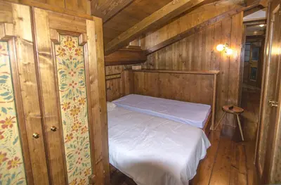 a small bedroom with a bed in a wooden cabin at Appartamento panoramico vicino centro in Cortina dʼAmpezzo