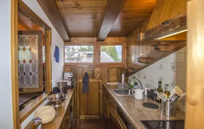 a kitchen with wooden cabinets and a counter top at Appartamento panoramico vicino centro in Cortina dʼAmpezzo