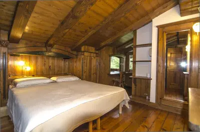 a bedroom with a bed in a wooden room at Appartamento panoramico vicino centro in Cortina dʼAmpezzo