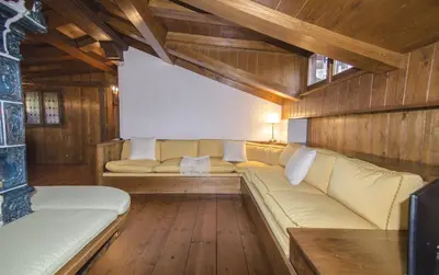a living room with a couch and wooden floors at Appartamento panoramico vicino centro in Cortina dʼAmpezzo