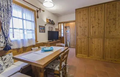 a living room with a wooden table and a tv at Un angolo di relax sulle Dolomiti ampezzane in Cortina dʼAmpezzo