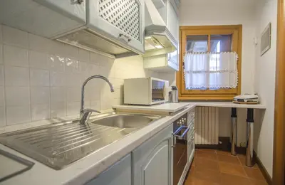 a kitchen with a sink and a microwave at Un angolo di relax sulle Dolomiti ampezzane in Cortina dʼAmpezzo