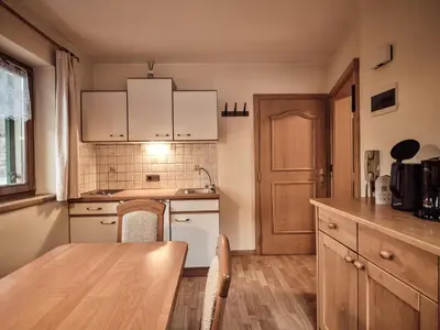 a kitchen with white cabinets and a wooden table at Fermeda in Villnoss