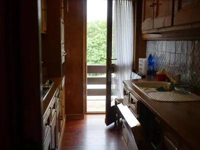 a kitchen with a sink and a door to a porch at Ca dell'Alba in Cortina dʼAmpezzo