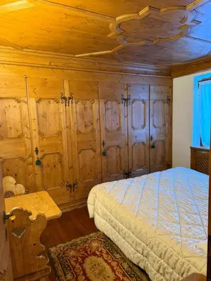 a bedroom with a bed with wooden walls and a ceiling at Ca dell'Alba in Cortina dʼAmpezzo