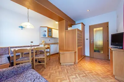 a living room with a kitchen and a dining room at Apartments Jasmin in Selva di Val Gardena