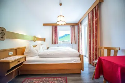 a bedroom with a bed and a window at Apartments Jasmin in Selva di Val Gardena