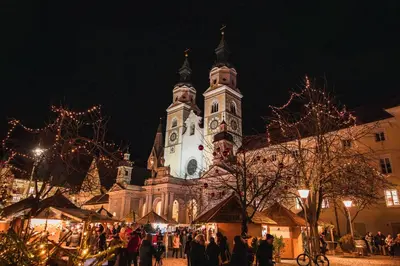 a large church with a clock tower at night at Praterhof Chalet in Südtirol - Natur, Ruhe & Bergblick in Bressanone