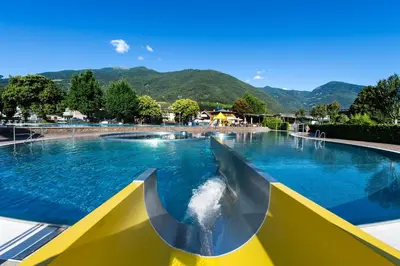 a large swimming pool with a water slide at Praterhof Chalet in Südtirol - Natur, Ruhe & Bergblick in Bressanone