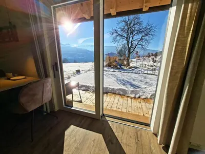 a sliding glass door with a view of a snow covered yard at Praterhof Chalet in Südtirol - Natur, Ruhe & Bergblick in Bressanone