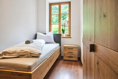 a bedroom with a wooden bed with a window at Linslhof in Terlano