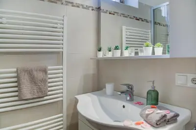a white bathroom with a sink and a mirror at Linslhof in Terlano