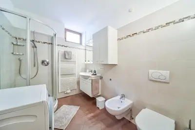 a white bathroom with a toilet and a sink at Linslhof in Terlano