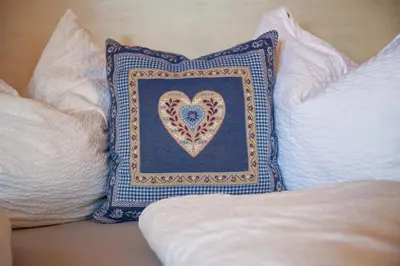 a pillow with a heart on it sitting on a couch at Linslhof in Terlano