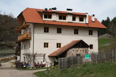 a large white house with a red roof at Kinighof 5 in Soprabolzano