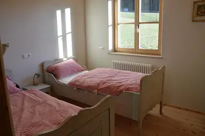 two beds in a room with a window at Kinighof 5 in Soprabolzano