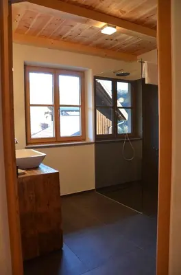 a bathroom with a sink and a glass shower at Kinighof 5 in Soprabolzano