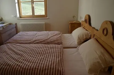 a bedroom with two beds and a window at Kinighof 5 in Soprabolzano