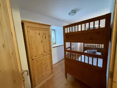 a room with a bunk bed next to a door at Il Molino nel bosco - PT in Alleghe