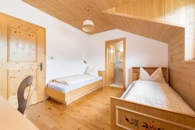 a large bedroom with a bed and a mirror at Room Erika, Obertörgglerhof in Brixen
