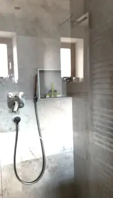 a bathroom with a shower with a hose at Room Erika, Obertörgglerhof in Brixen