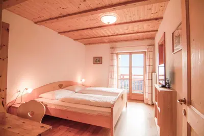 a bedroom with a bed and a large window at Berggasthof Messnerhof in Barbiano
