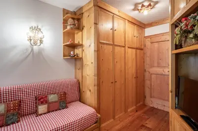 a living room with a couch and a tv at Cozy basement flat just few steps from centre in Cortina dʼAmpezzo