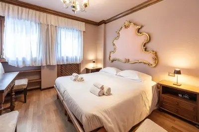a bedroom with a large bed with towels on it at Casa Cavallino, in centro a Cortina dAmpezzo in Cortina dʼAmpezzo