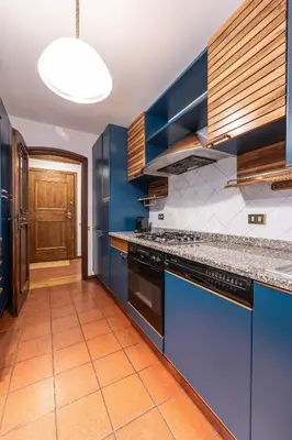 a kitchen with blue cabinets and an orange tile floor at Casa Cavallino, in centro a Cortina dAmpezzo in Cortina dʼAmpezzo