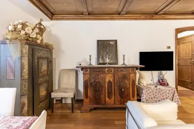 a living room with a large wooden cabinet and a tv at Casa Cavallino, in centro a Cortina dAmpezzo in Cortina dʼAmpezzo