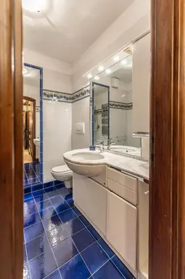 a bathroom with a sink and a toilet and a mirror at Casa Cavallino, in centro a Cortina dAmpezzo in Cortina dʼAmpezzo